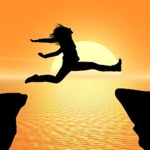 Woman jumping across a chasm to illustrate good planning