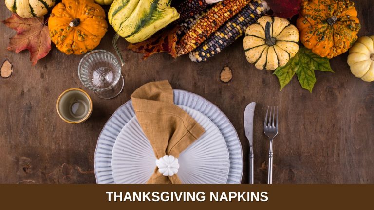 A white plate setting with a burlap-looking napkin, surrounded by fall decor made of gourds, corn husks, and small pumpkins.