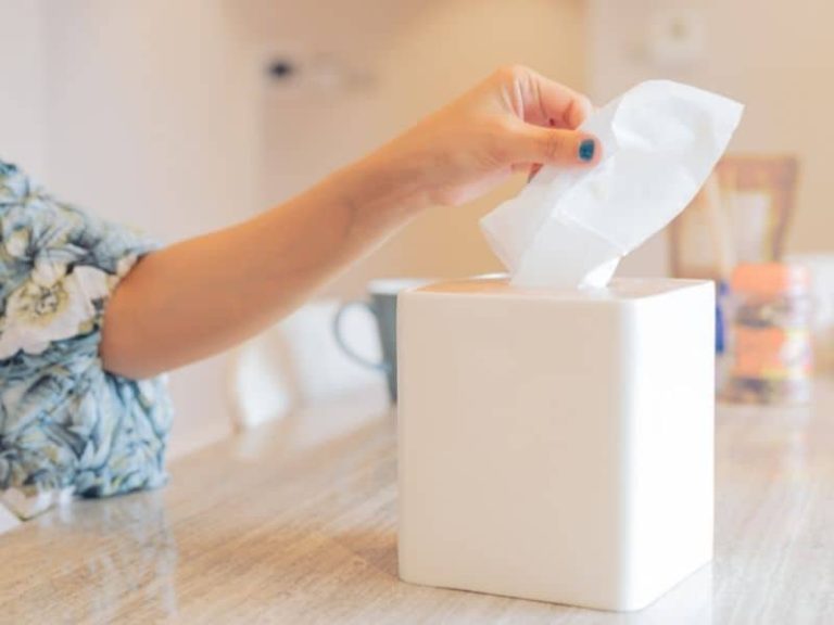 Woman pulling a tissue out of a tissue box