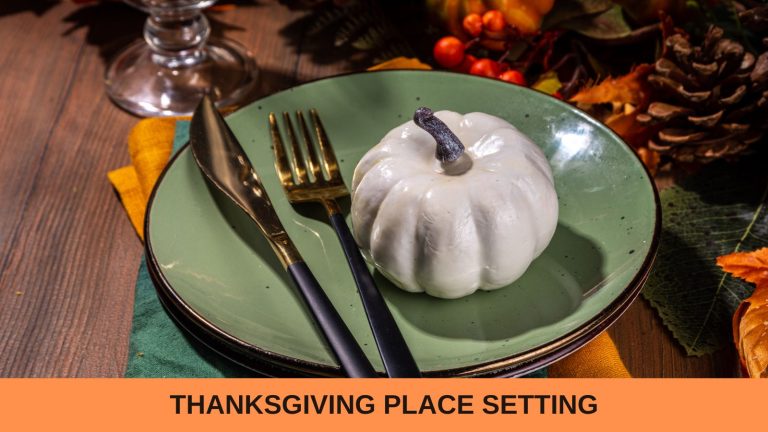 Thanksgiving place setting: a green plate set on an orange towel, and with a white pumpkin sitting on the plate.